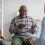 Cheerful-African-American-Elderly-Man-Having-Conversation-With-Coach.jpg